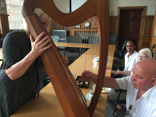Helen showing the red strings on her harp to the some of the members of Dementia Club UK Helen showing the red strings on her harp to the some of the members of Dementia Club UK